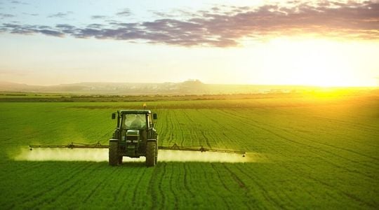 Un agriculteur épand des engrais sur son champ