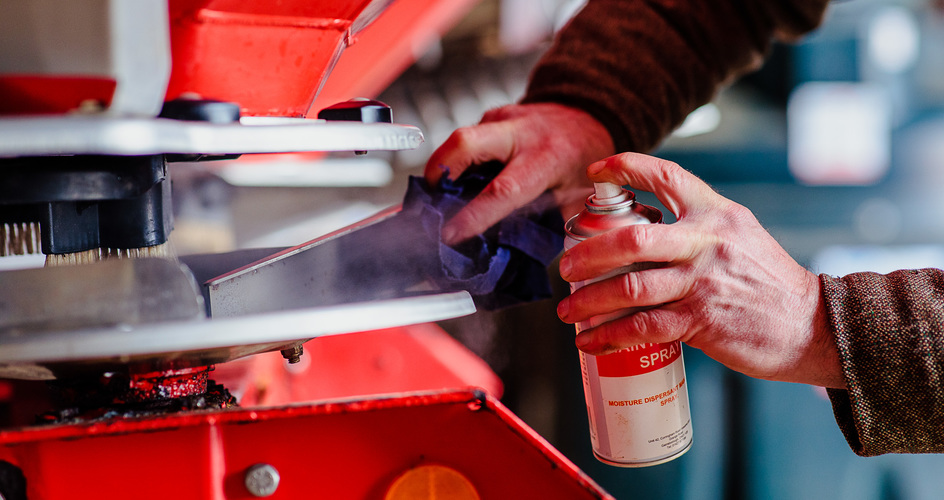 Un homme nettoie un épandeur
